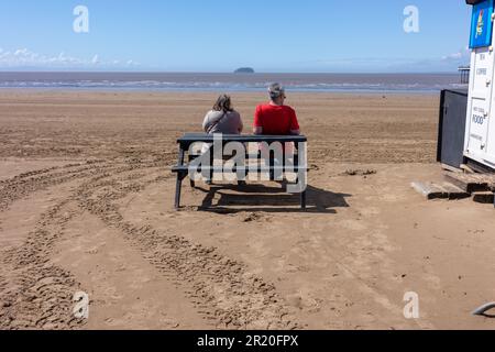 Couple sat on a bench looking out to the sea at Weston super mare Stock Photo