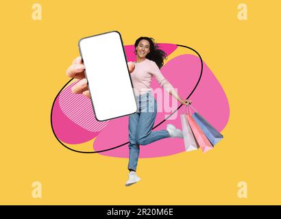 Online Sales. Happy Woman Jumping With Shopping Bags And Big Blank Smartphone Stock Photo