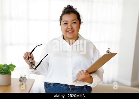 Portrait of professional family counselor hispanic woman posing in clinic Stock Photo