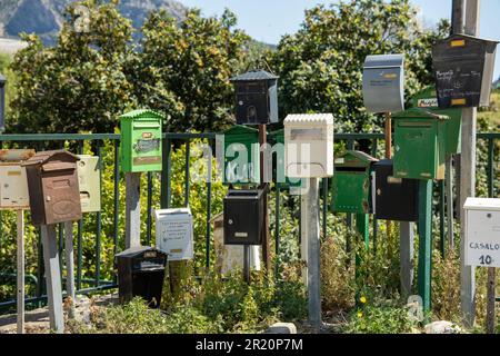 various colored mailboxes along the side of the road Stock Photo