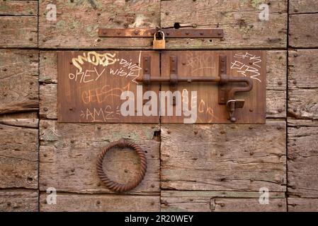 Rusty door bolt, sliding latch and padlocks on old wooden door, Trastevere, Rome, Italy Stock Photo