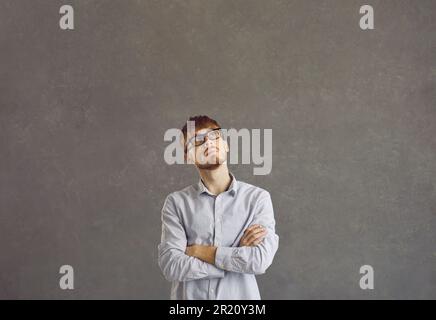 Portrait of a serious caucasian young man with a pensive expression on a gray background. Stock Photo