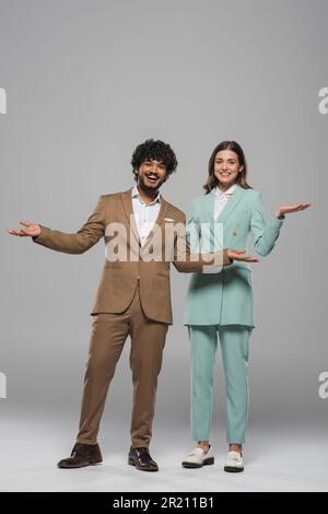 Cheerful and young indian host of event with curly hair standing in 