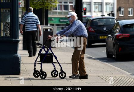 Photograph of an elderly man wearing a face mask on a street in Hornchurch, Essex amid the COVID-19 coronavirus pandemic. Stock Photo