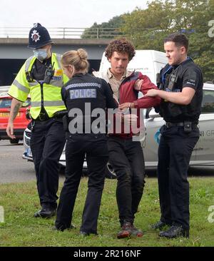 United Kingdom: Police arrest climate change protesters who attempted to block the M25 at junction 28 near Brentwood, Essex as they demand government action on home insulation. Stock Photo