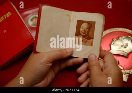 During the Cultural Revolution, Mao's personality cult manifested itself in the ubiquitous wearing of badges depicting Chairman Mao, and people carrying around a Little Red Book with the writings of Mao, which would be studied and quoted from at every opportunity. Stock Photo