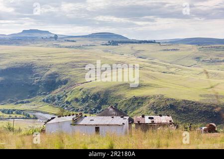 Rural houses in the Drakensburg mountains in Kwa-Zulu Natal with a view of the valley and hills and cloudy sky Stock Photo
