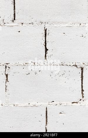 Rough and white wall made with big blocks or paver of cement and stone. Vertical. Stock Photo