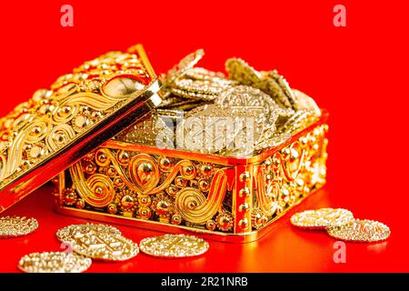Golden Box Filled with Golden Coins Isolated on a Red Background Stock Photo