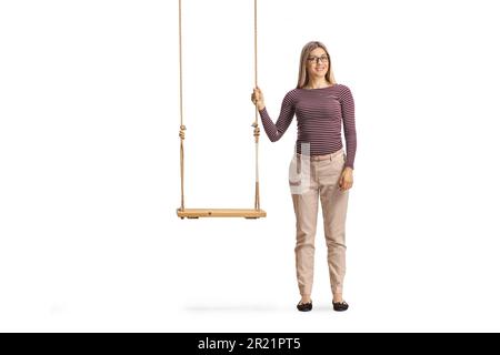 Full length portrait of a woman standing next to wooden swing isolated on white background Stock Photo