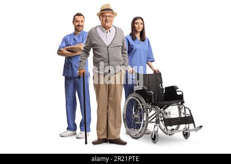 Elderly man and medical workers in blue uniforms standing with a wheelchair isolated on white background Stock Photo