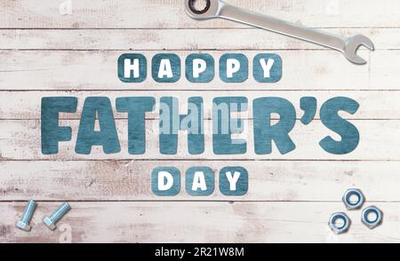 Happy Father's Day Wooden lettering on white wooden background with tools and nuts and bolts Stock Photo