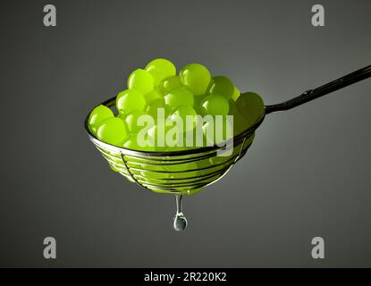 green jelly balls for making bubble tea in a strainer on grey background Stock Photo