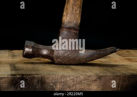 close up of hammer on wood with black background with reduced vibrance, grungy, old, antique, vintage Stock Photo