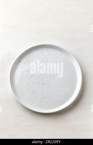 empty white plate on white table top view Stock Photo