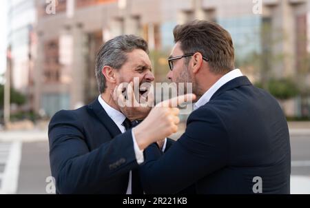 two businessmen have business conflict and blaming each other outdoor. fighting businessmen have business conflict. photo of businessmen have business Stock Photo