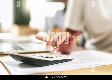 Calculating my future finances. a businesswoman using a calculator to budget her finances. Stock Photo
