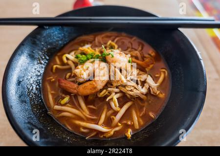 Sarawak Laksa soup in street food kitchen, in Malaysia. Laksa is a popular noodle dish in Malaysia and Singapore. Stock Photo