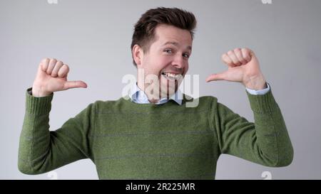 The European young man proudly points at himself, saying I am good with myself Stock Photo