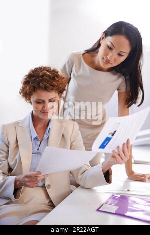 Reviewing the financial report. two female colleagues working together in the office. Stock Photo