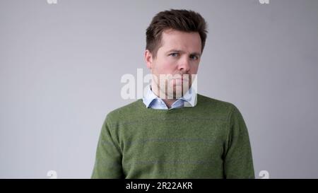 European, young man, shakes his head in disbelief and looks skeptically into the camera Stock Photo