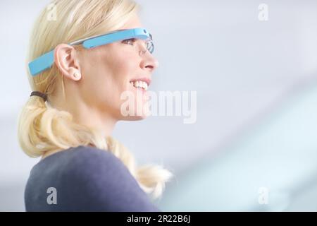 Modern business meets future technology. a young woman standing in an office wearing smart glasses. Stock Photo