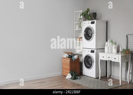 Interior of laundry room with washing machines, table and basket Stock Photo