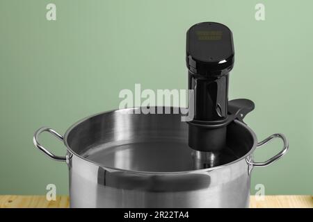 Sous vide cooker in pot on table, closeup. Thermal immersion circulator Stock Photo