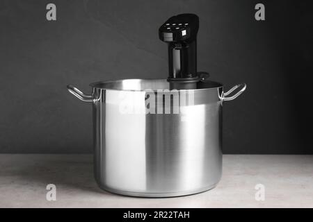 Sous vide cooker in pot on light grey table. Thermal immersion circulator Stock Photo