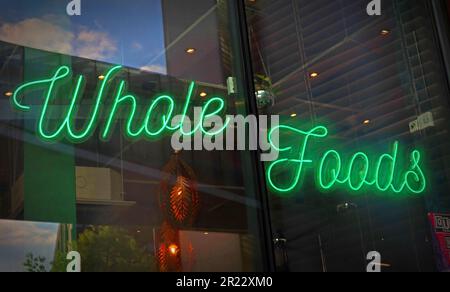 Green neon sign in Vegetarian restaurant, Liverpool - Whole Foods Stock Photo