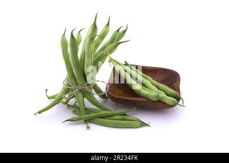 Bundle green beans bonded with jute rope near beans in a wooden bowl isolated on white background Stock Photo