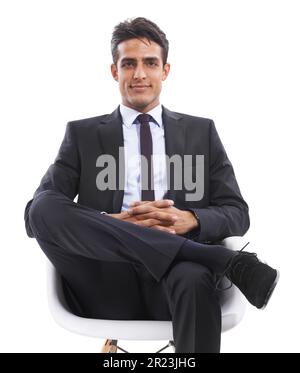He enjoys his career. Portrait of a handsome young businessman sitting in a chair against a white background. Stock Photo