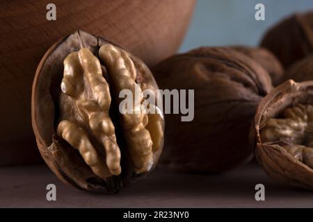 Walnut kernels and cracked walnuts on wooden table Stock Photo