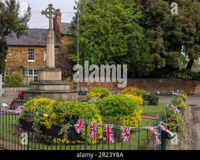 Village green with war memorial and Union Jack bunting, Hardingstone, Northampton, UK Stock Photo