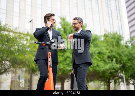 Caucasian employee on urban background office building texting messages on mobile phone. Business man standing a formal suit using smartphone Stock Photo