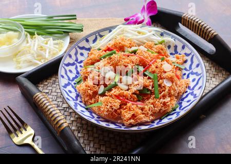 Mee Krob - Thai appetizer of  Mixed Crispy Rice Noodle served in bamboo tray at close up view,  Authentic Thai food Stock Photo