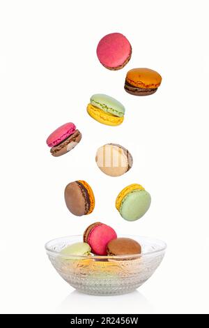 Flying macarons falling in a vintage plate isolated on white background Stock Photo