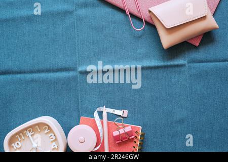 Pink stationery office supply on blue fabric desk background. flat lay, top view, copy space Stock Photo