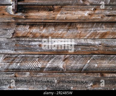 Old weathered wooden wall with horizontal boards and rusty nails in it. Rustic background or texture. Stock Photo