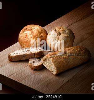 Arrangement of assortment of baked bread in a dark ambiance Stock Photo