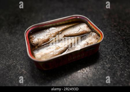 Selective focus and creative backlight on a can in sardines in oil against black marble Stock Photo