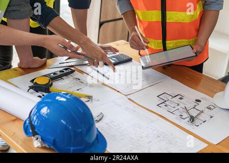 construction engineers team using blueprint and tablet of project plan brainstorming and working together at construction building, Architecture and Stock Photo