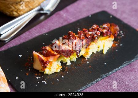 Pulpo a la Gallega. Octopus cooked with boiled potato, paprika and olive oil. Galician octopus recipe north of Spain tapa. Stock Photo