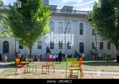 Boston, MA, USA-September 2022; View over Harvard Yard of Harvard University with brightly colored Luxembourg Chairs in front and University Hall Stock Photo