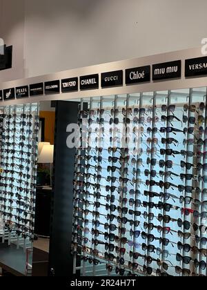 Poland, Warsaw - July 12, 2022: Many stylish sunglasses from popular brands on racks in shopping mall Stock Photo