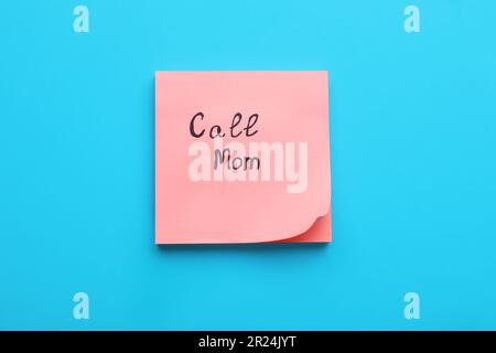 Paper note with phrase Call mom on light grey background, top view ...