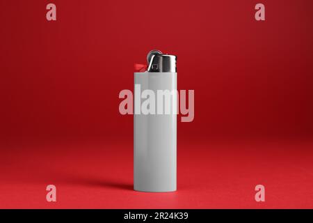 Stylish small pocket lighter on red background Stock Photo