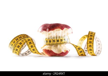 Red apple wrapped with tape measure on isolated white background. Healthy eating and lifestyle concept. Stock Photo