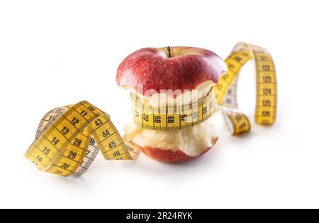 Red apple wrapped with tape measure on isolated white background. Healthy eating and lifestyle concept. Stock Photo