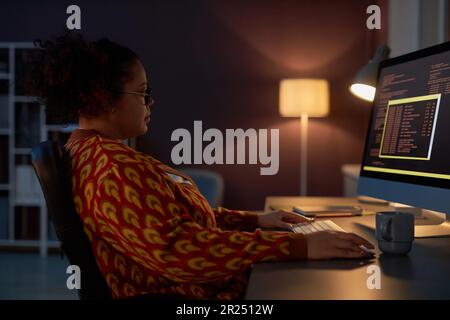 African American woman working with computer codes while working at his workplace in office till late night Stock Photo
